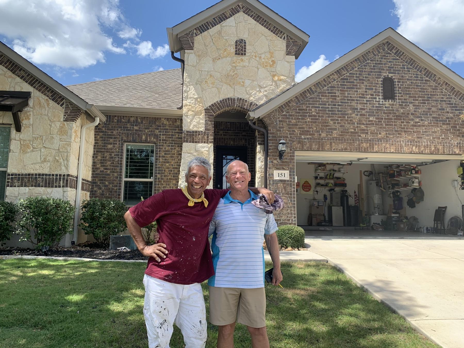 Michael Ramirez with a happy customer in front of their home