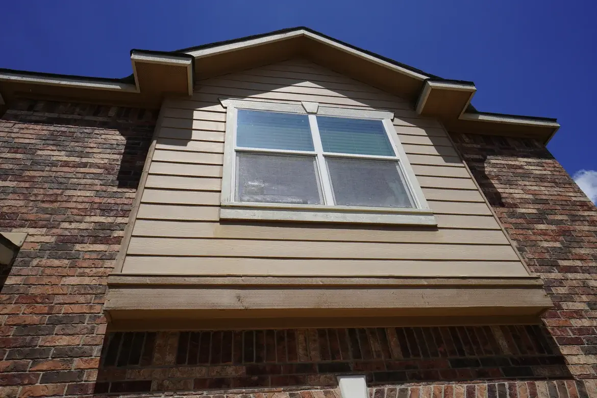 Garage gable before painting with weathered white window trim