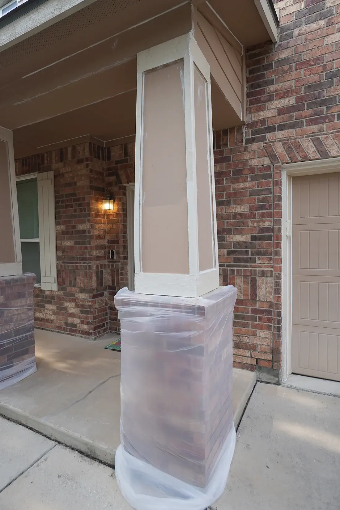 Plastic protecting the porch's brick column base while the wood column is painted