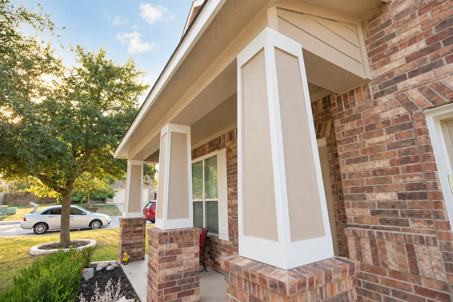 Finished porch columns and trim beside the brick exterior