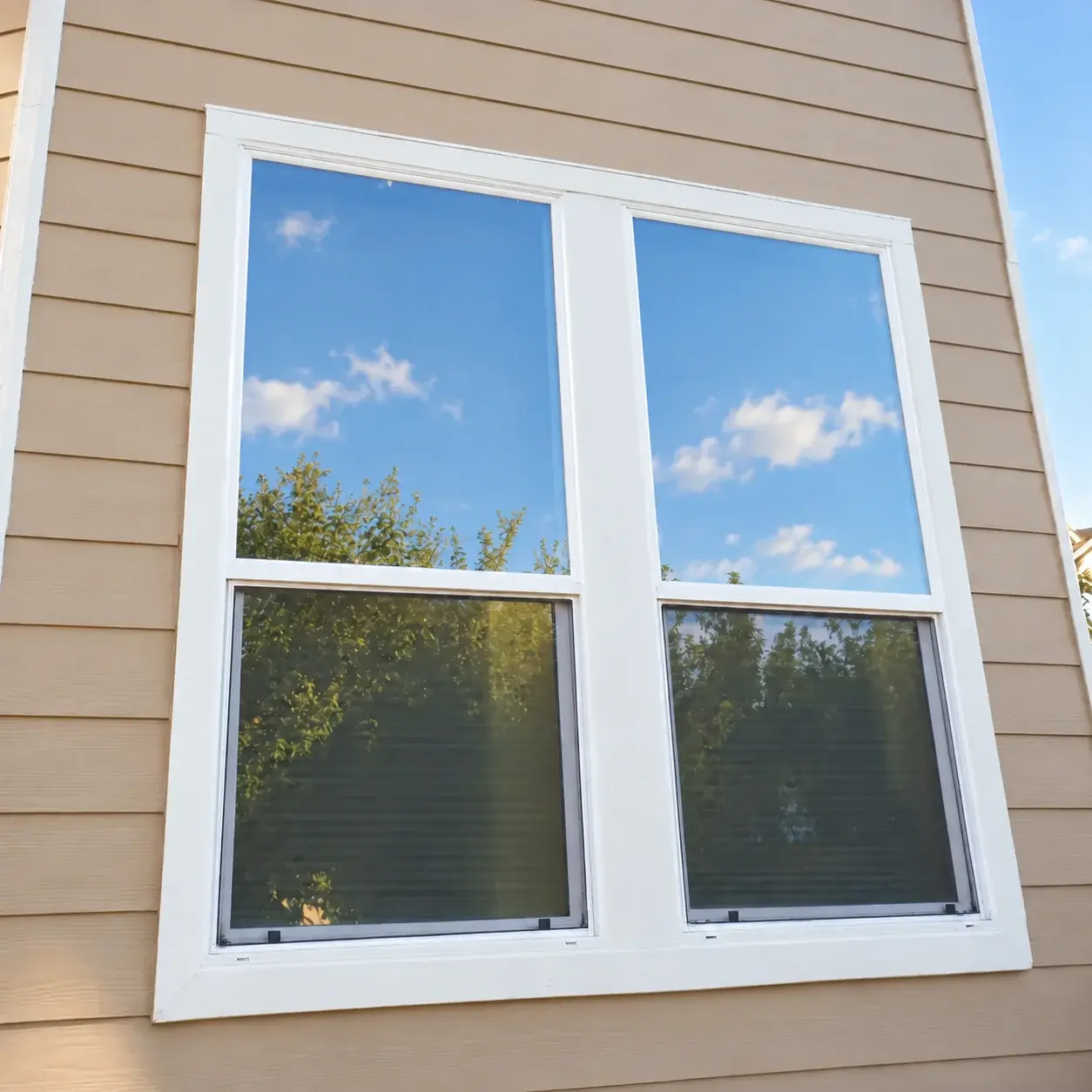 The same double windows with replacement white trim and completed exterior painting
