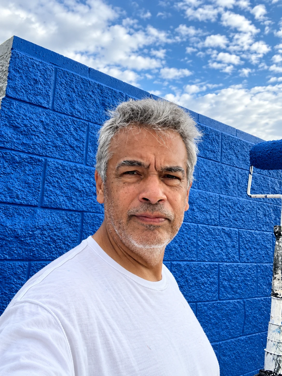 Michael Ramirez beside a freshly painted blue wall
