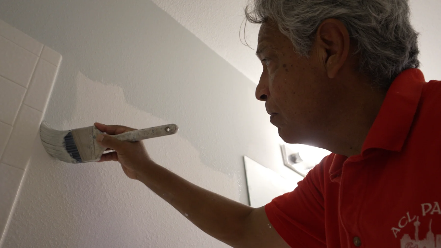 Michael Ramirez painting an interior with a brush