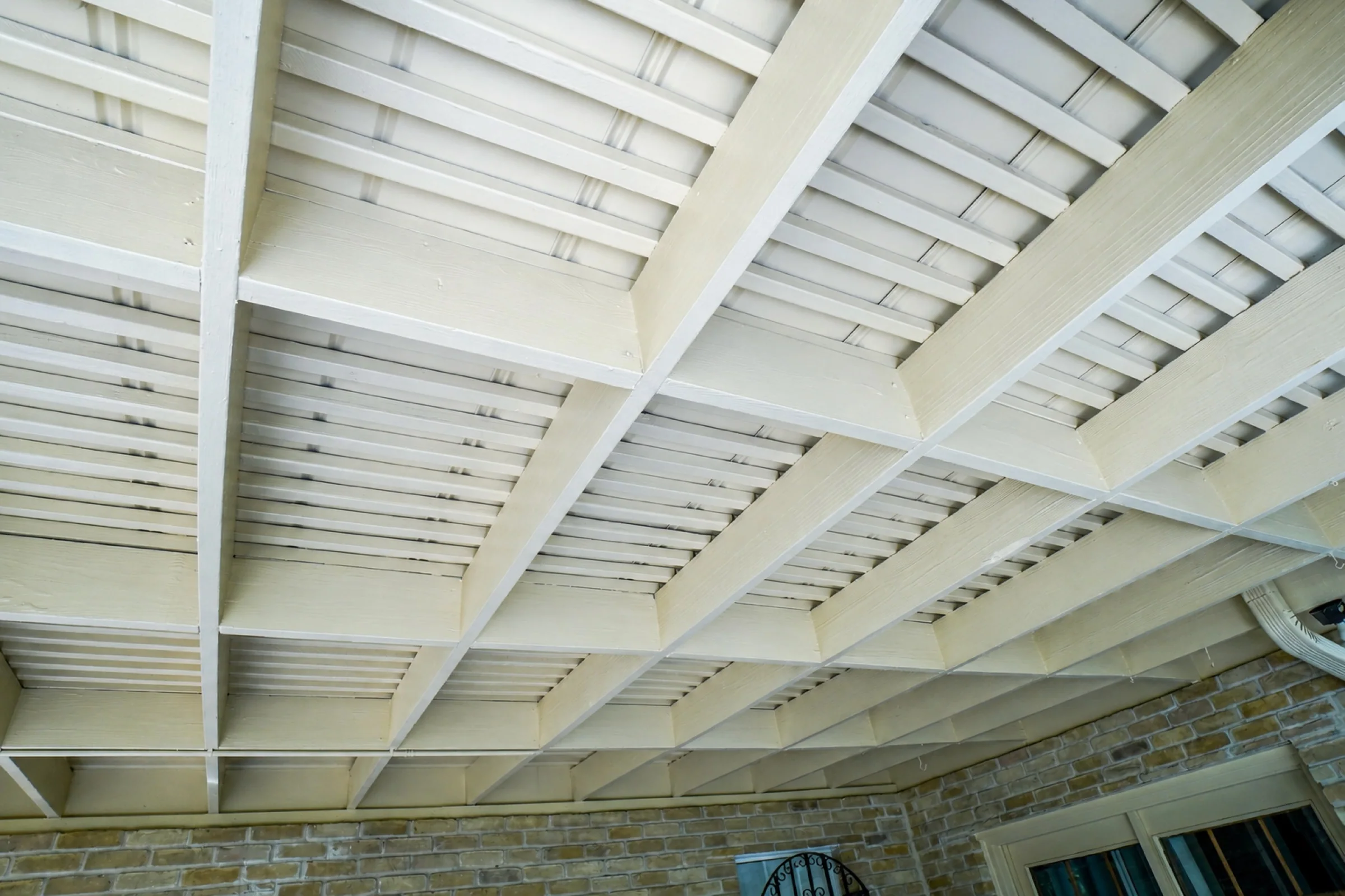 Finished painted beams and ceiling over a covered patio